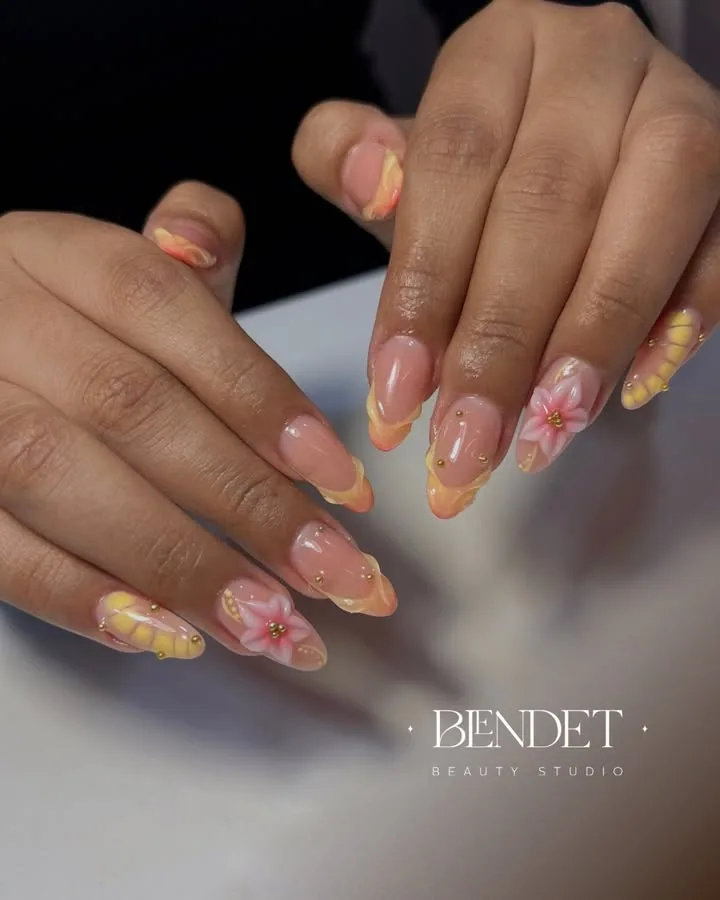 Uñas durazno con flores en relieve y perlas doradas